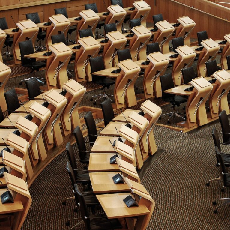 A horizontal shot of the desks inside of the Scottish parliament building